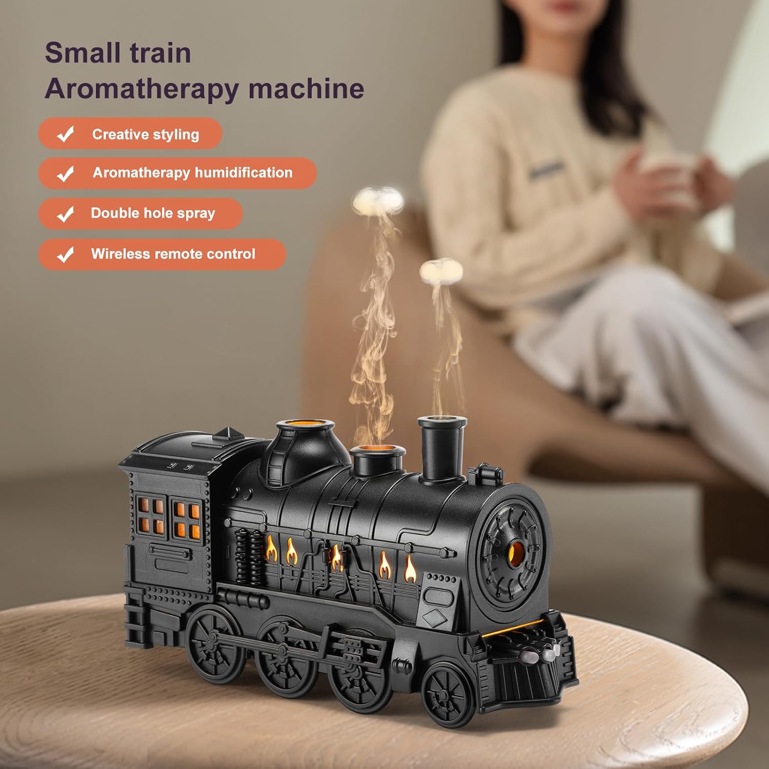 Black train-shaped aromatherapy machine on a wooden surface with a blurred person in the background.