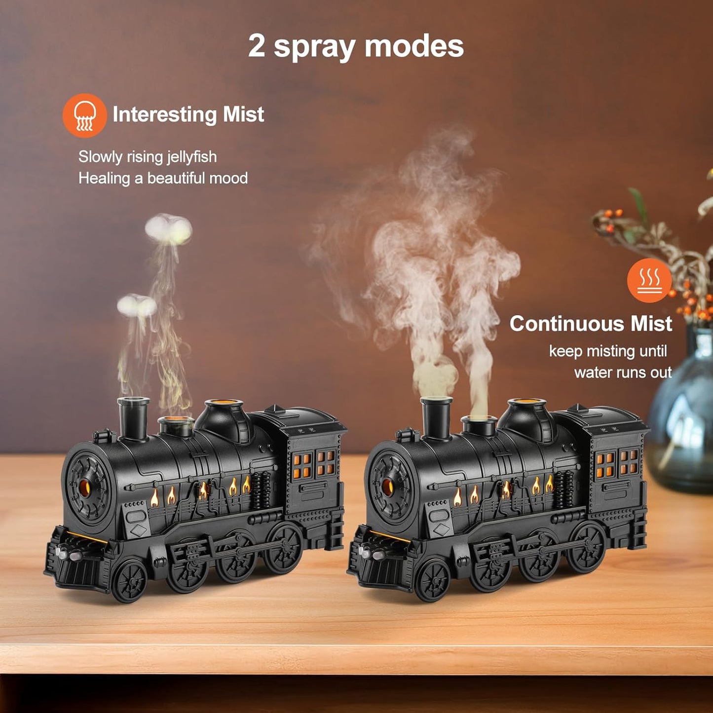 Two black train-shaped diffusers on a wooden surface with mist effects.