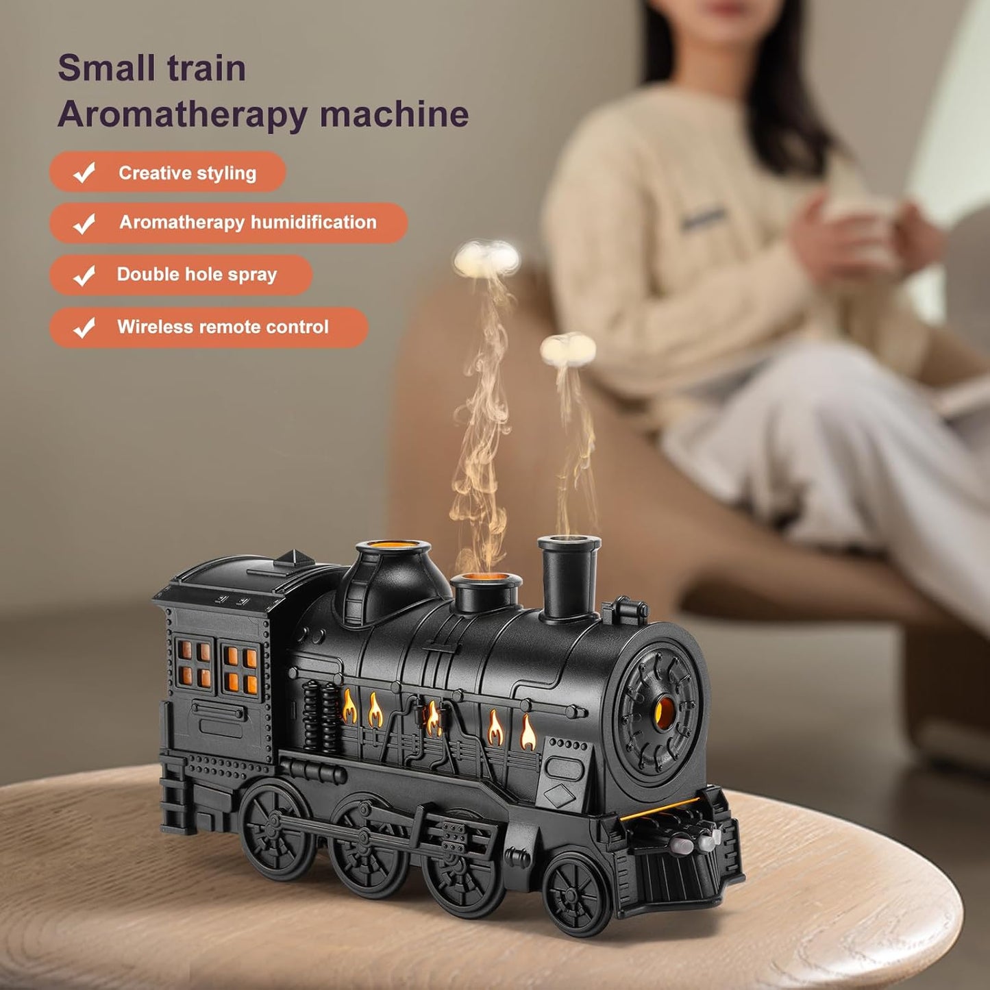 Black train-shaped aromatherapy machine on a wooden surface with a blurred person in the background.